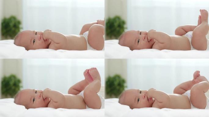 亚洲新生婴儿在床上吮吸手指