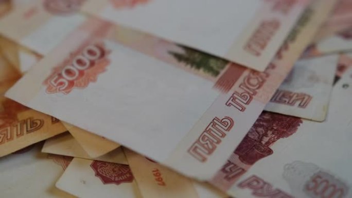许多俄罗斯纸币躺在顺时针旋转的平台上。