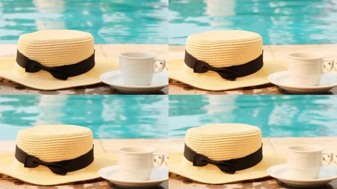 在夏天阳光明媚的日子里，一杯咖啡和一顶草帽在游泳池的背景上。早上好概念，并计划新的一天，一周，一个月