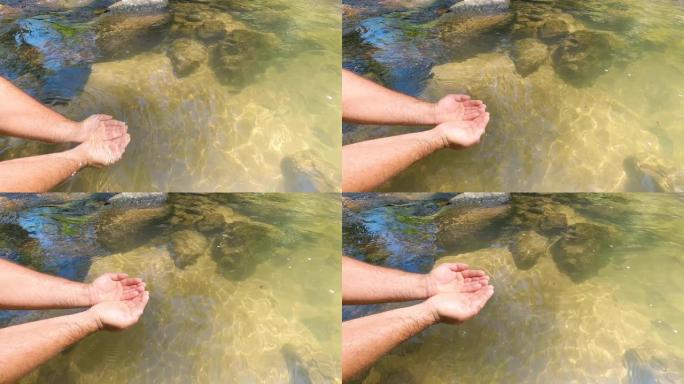 晴天双手从瀑布中捞水的视频。用手接水。清澈的溪流。与家人一起享受大自然，旅行，瀑布之旅