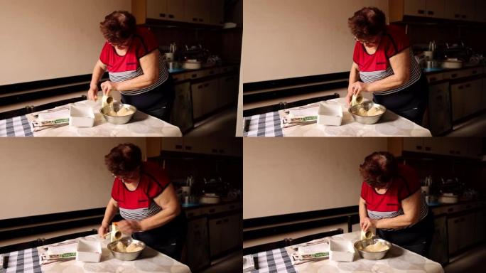在她的厨房里，高级妇女用手动磨碎核桃