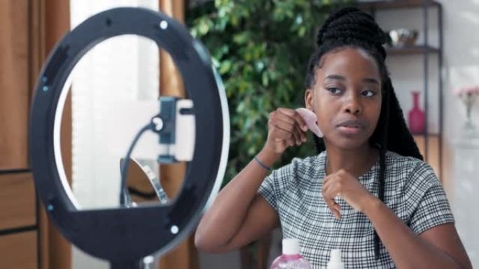 Beauty influencer主持了一个带有护肤技巧的实时流媒体频道。女方录一份刮痧石面部按摩教