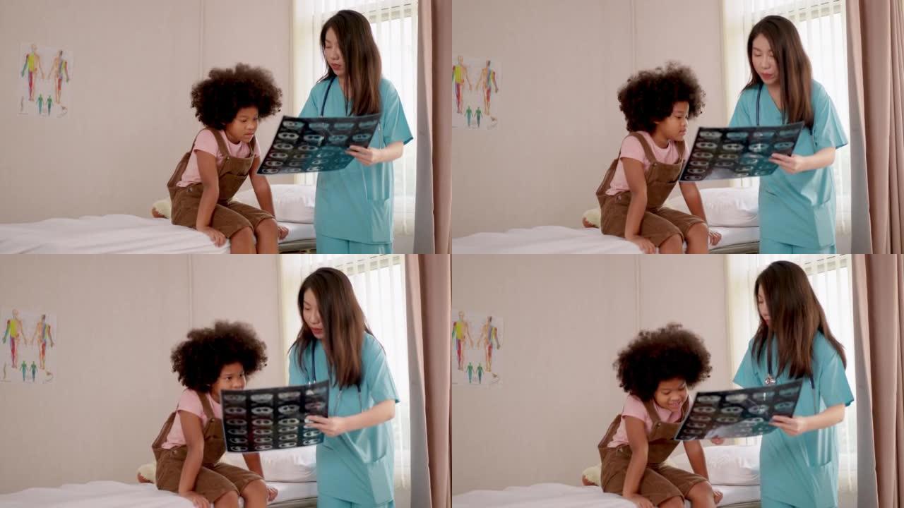 专业知识美丽的护士穿着医院的长袍显示和解释x射线扫描图像给坐在医院病床上的儿童患者。放射学、保健、外