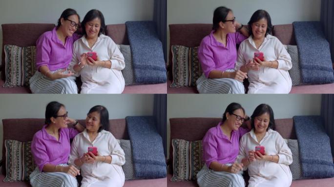 女儿和她的母亲在智能手机上观看照片