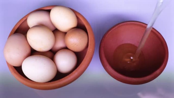 一个碗里有很多鸡蛋，另一个碗里有碎鸡蛋。