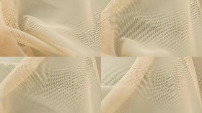 米色细网特写。缝制婚纱。轻质尼龙面纱。手工剪裁，专业服装理念。摘要背景
