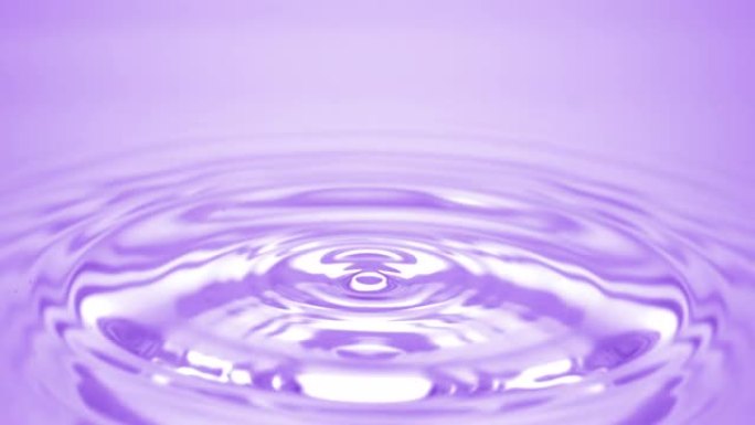 水滴落在紫色流体表面，形成水环