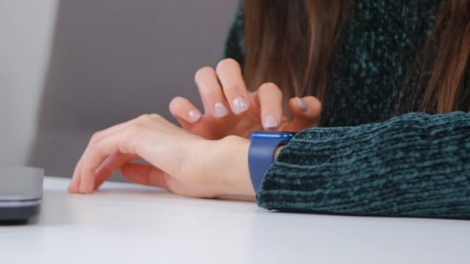 特写镜头中使用智能手表的年轻女子。女性在连接到5g互联网的现代智能手表设备上浏览通知
