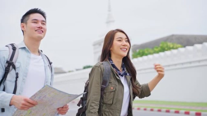 亚洲迷人的浪漫情侣在城市里度蜜月旅行。年轻的新婚男女背包客游客叫出租车运输，一起度过假期