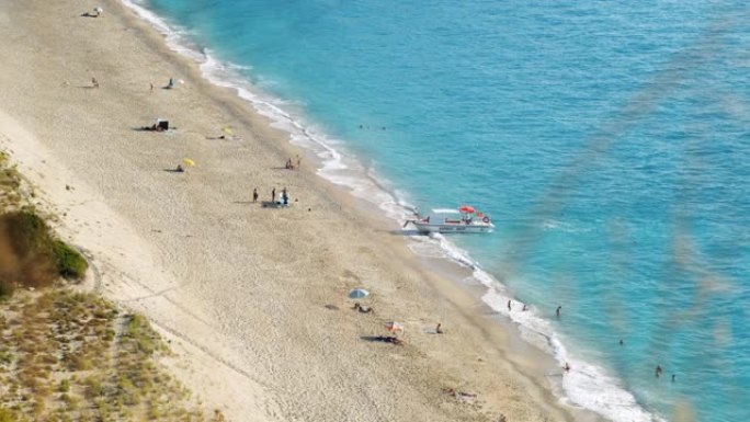 希腊莱夫卡斯，夏日之光中的米洛斯海滩。跳上船接游客