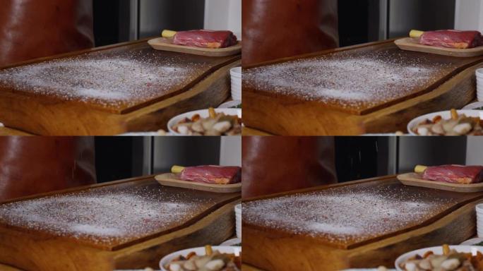 将盐和胡椒粉撒在碎木机上，用于新鲜生肉。