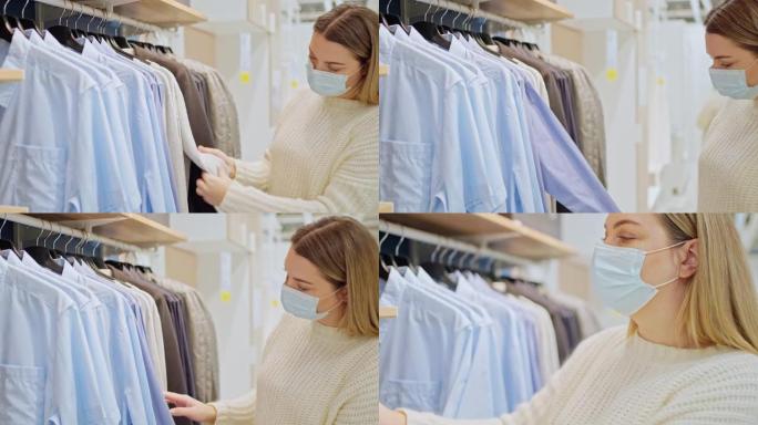 戴着防护面具的年轻女子在商店检查衣架上的衣服
