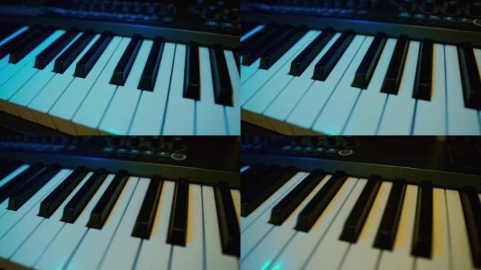 Midi键键盘。琴键在移动。黑白钥匙。彩色霓虹灯。向后跟踪镜头。特写