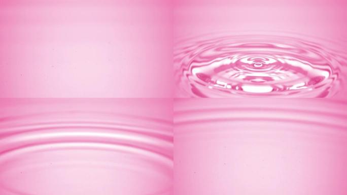 水滴落在粉红色的流体表面上，形成水环