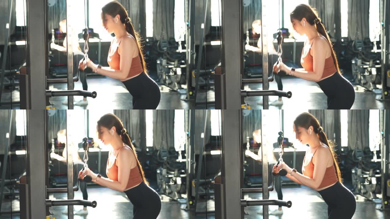 在健身房锻炼的亚洲美女，她正在下拉减肥机上锻炼