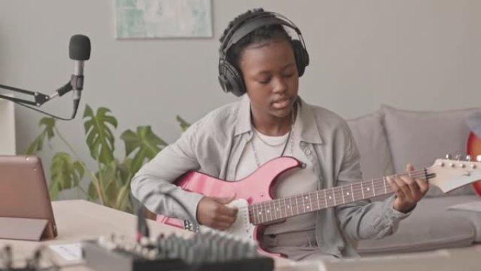 戴着耳机玩电吉他的非洲裔美国女孩