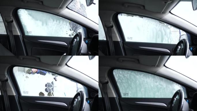 在自动洗车时，用泡沫从覆盖窗户的机舱清洗汽车视图