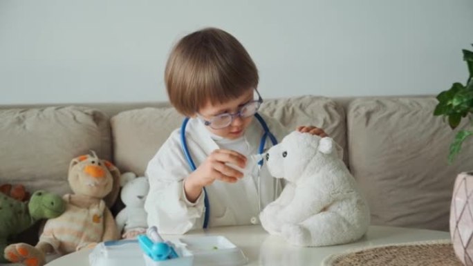穿着医用外套的小医生用听诊器玩治疗流鼻涕，玩具泰迪熊的鼻腔喷雾