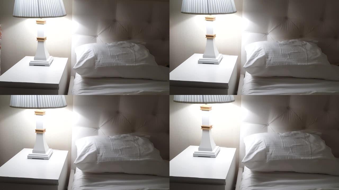 4k视频，豪华酒店床，准备睡觉，带灯的床头柜和带枕头的干净白色床单，晚上