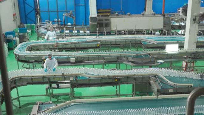 2名亚洲华人水厂生产线工人，携带个人防护用品，日常检查水瓶工作