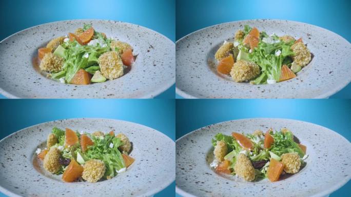 沙拉，葡萄柚，绿色生菜，鳄梨，金枪鱼和奶酪放在灰色盘子上，在蓝色背景上旋转特写。餐厅食物。意大利沙拉