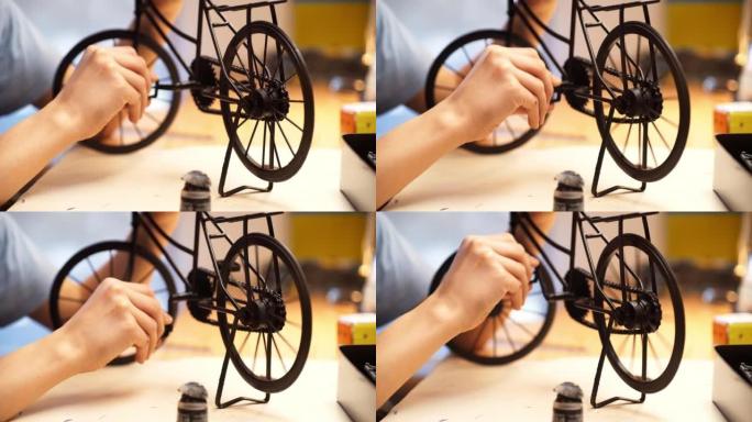十几岁的男孩在做自行车模型。坐在他的房间里，靠近手和细节