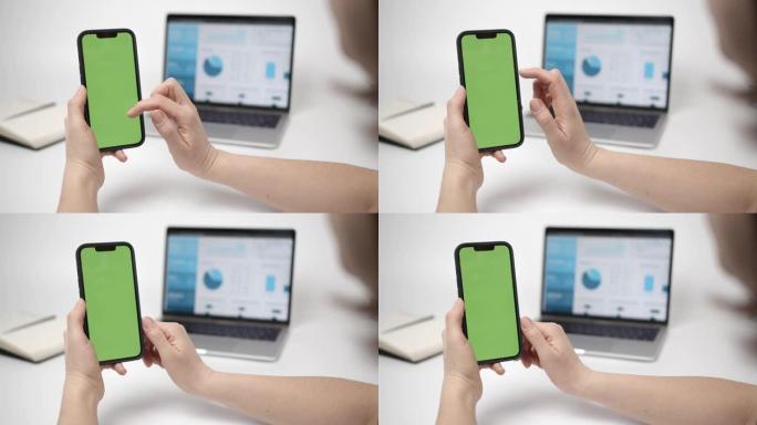 手握智能手机上的色度键模型。使用绿屏手机的女人