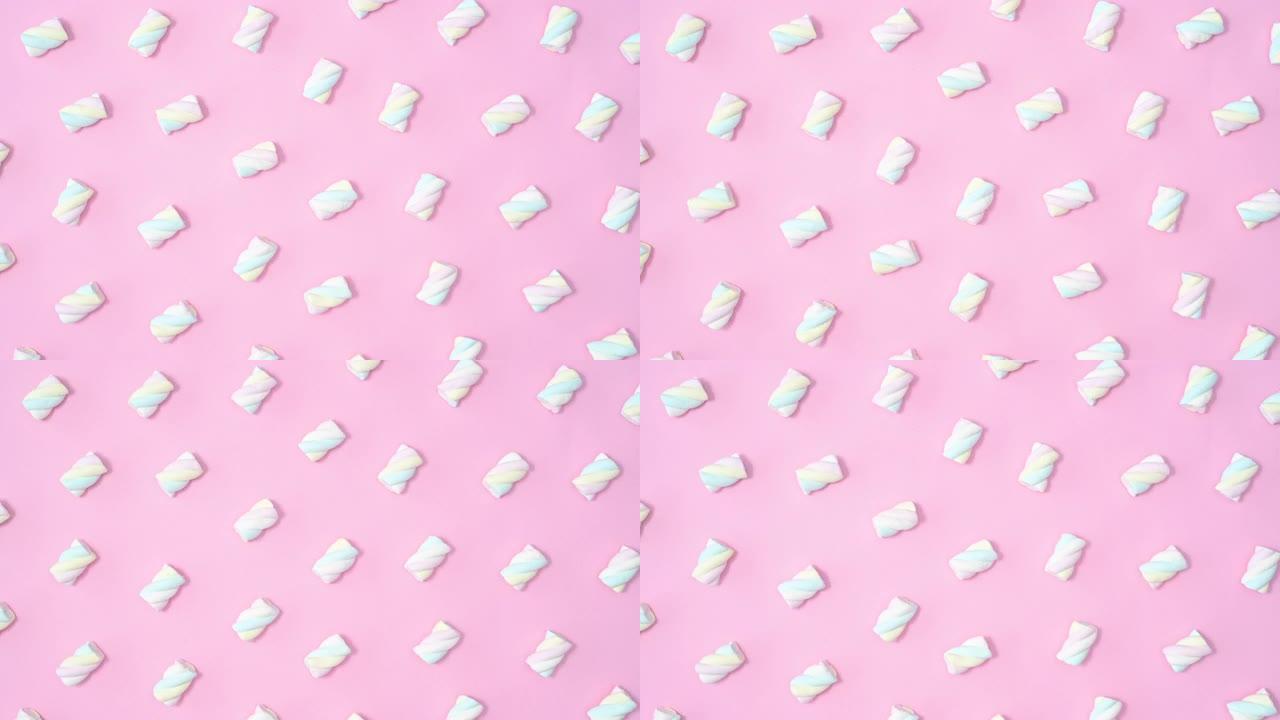 创意甜美的图案，棉花糖糖果在柔和的粉红色背景上移动。停止运动平铺