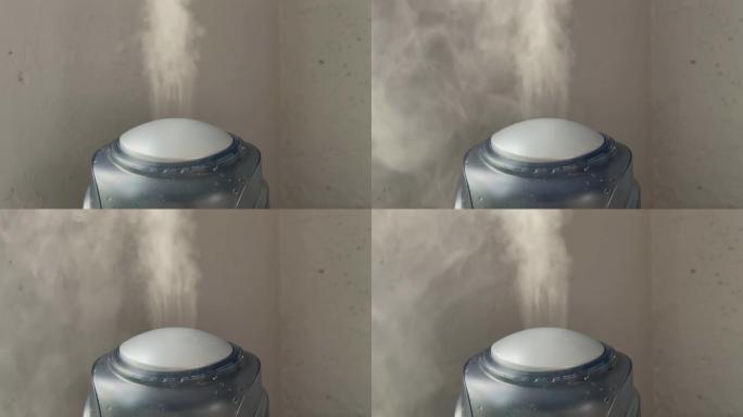 加湿器在灰色墙壁背景上工作。来自加湿器的水雾蒸汽。