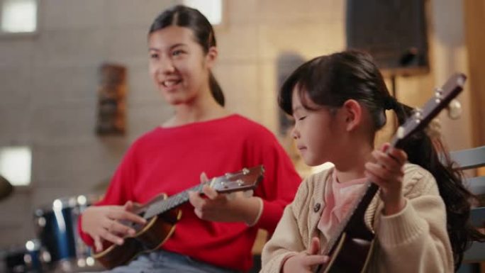 MS-两个年轻女孩一起学习演奏夏威夷四弦琴