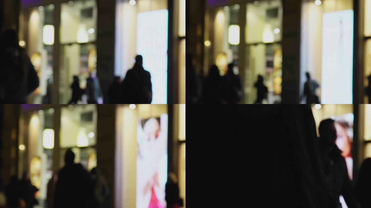 在市中心的steet夜生活中，商店门面bokeh的旅行者购物视线的抽象模糊运动镜头