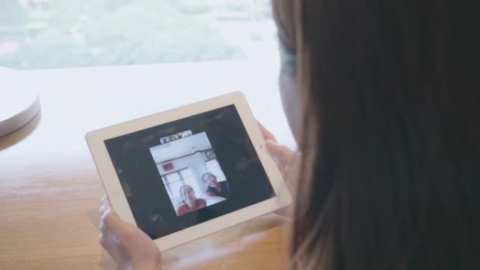 女人使用数字平板电脑和手机与家人进行社交电话会议