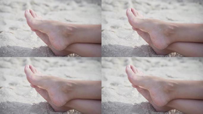女性腿上的拇外翻在沙滩上。足关节畸形。人体的保健和医学问题