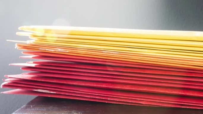 多利蒂彩色信封堆放在桌子上，阳光自然。