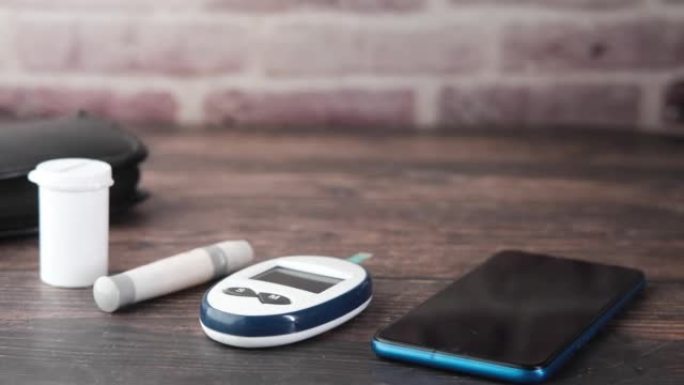 桌上的智能手机和糖尿病测量工具和药丸