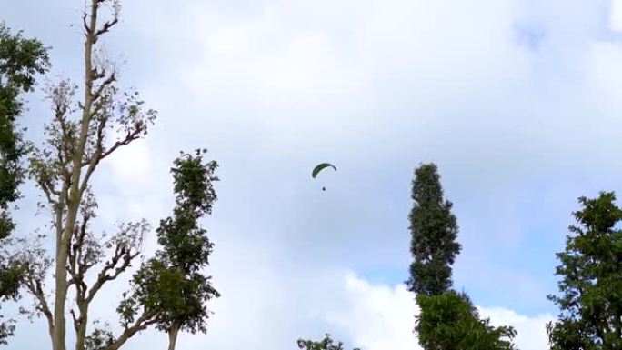 在印度古吉拉特邦的Saputara享受空中滑翔伞的游客的景色。在萨普塔拉体验冒险活动的游客。带云的蓝