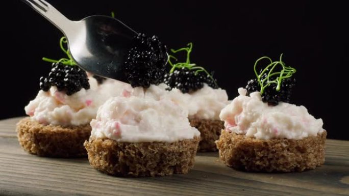 黑鱼子酱三明治特写。面包配咸白鲸鲟鱼鱼子。生海鲜。豪华美味食品。美味可口的鱼产品。俄罗斯美食。节日晚