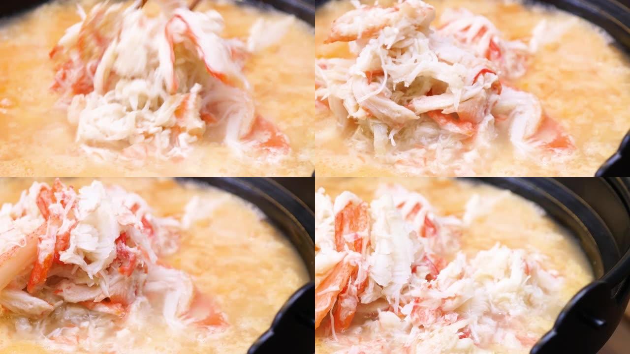 螃蟹粥的特写视频。蟹肉和鸡蛋放在火锅汤里的菜。