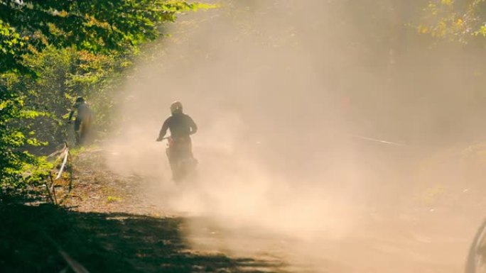 运动员、摩托车手在越野赛道上快速跑完全程。一场摩托车比赛后扬起的沙尘