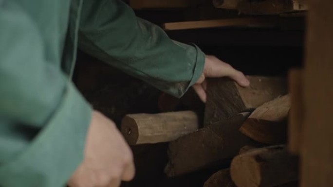 一位老人的手正在整理木头