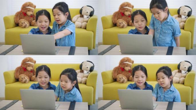两个亚洲女孩从家庭互联网，家庭学习，社交距离，电子学习在线学习。
