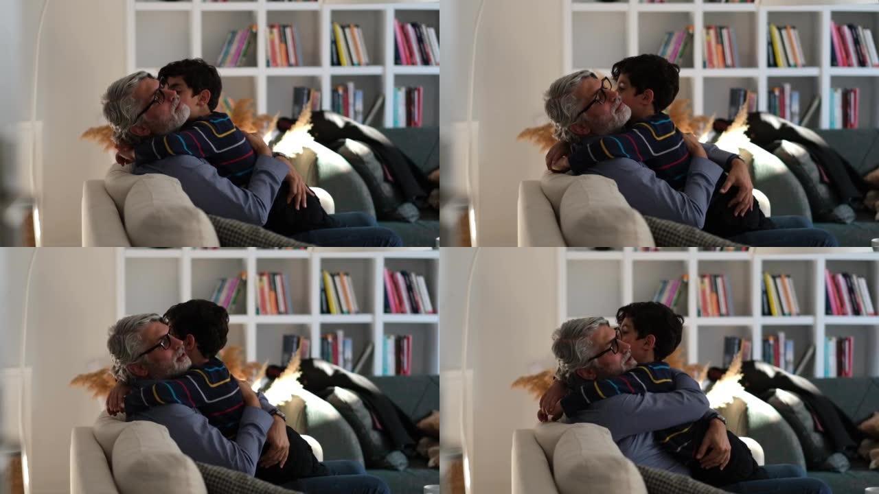 快乐的爸爸和学龄前的儿子一起在沙发上放松