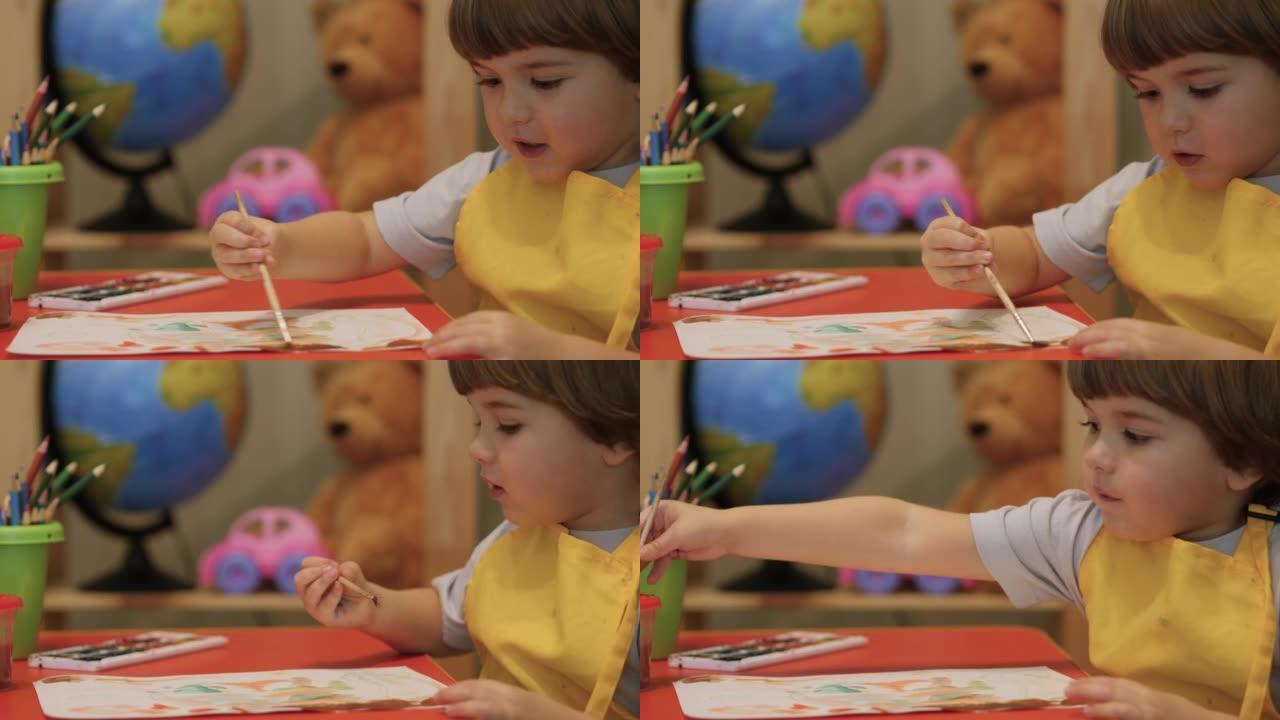 可爱的小男孩坐着画画。四岁的高加索男孩玩得开心，在纸上画画，富有创造性和艺术性。用彩色颜料在纸上特写