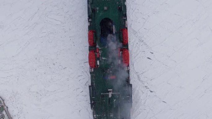 在一个寒冷的冬日，船破冰进入港口。一艘巨大的破冰船用船头破冰，漂浮在大型海冰浮冰中，俯视图。