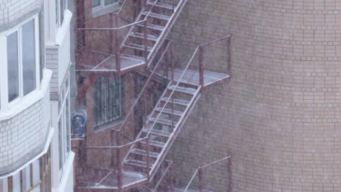 大雪背景下砖房的选美楼梯。雪季
