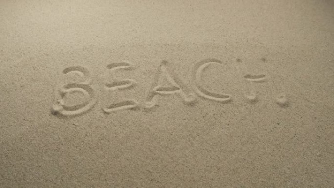沙滩上写的海滩这个词。滑块镜头