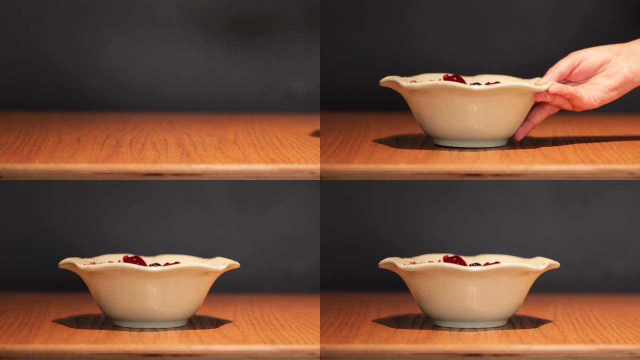 在木桌上盛上一碗健康的混合水果浆果