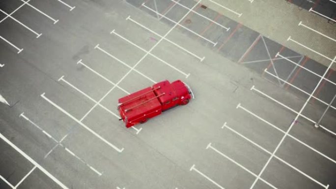 老式红色车辆，装有消防任务工具的老式消防车，在空停车场行驶。空中射击