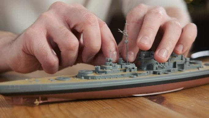 根据说明书制作的快乐成年男性装配工塑料战舰模型