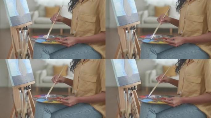 用画师在纸上画画，用手拿画盘制作带有颜色的艺术品。